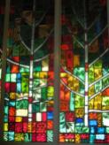 Summer season in stained glass along the wall of the chapel.