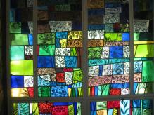 Spring season in stained glass along the wall of the chapel.